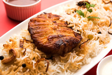 Authentic Fish Biryani served in a white plate over white background, selective focus