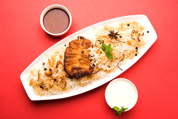 Authentic Fish Biryani served in a white plate over white background, selective focus