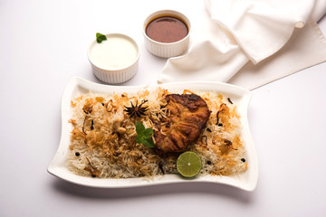 Authentic Fish Biryani served in a white plate over white background, selective focus