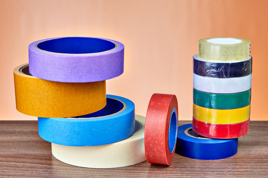 Multicolored rolls of insulation and masking tape lie on table.