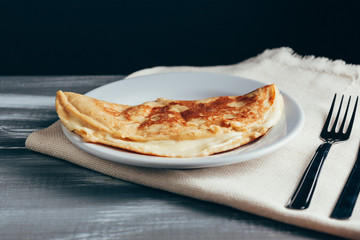 Crepioca - pancake of cassava (tapioca) with cheese on plate on wooden background. Selective focus