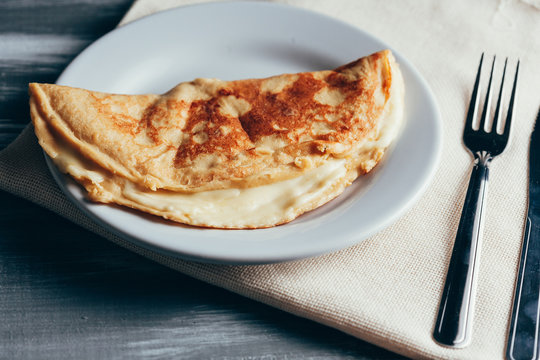 Crepioca - pancake of cassava (tapioca) with cheese on plate on wooden background. Selective focus