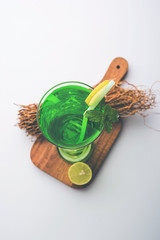 Khus Sharbat or Vetiver Drink served in a glass with Mint and Lemon slice, selective focus