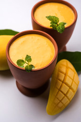 Mango Lassi, Indian popular summer drink in a terracotta glass, selective focus