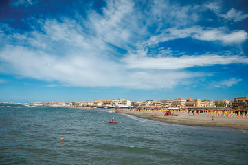 Overview of the beach and town of Ostia between the Mediterranean sea and sunny sky. The town is a...