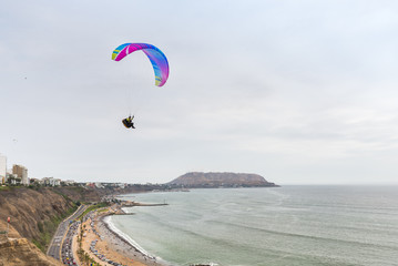 Paraglider flying above the Pacific coast 