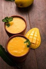 Mango Lassi, Indian popular summer drink in a terracotta glass, selective focus