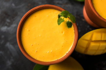 Mango Lassi, Indian popular summer drink in a terracotta glass, selective focus