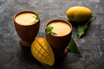 Mango Lassi, Indian popular summer drink in a terracotta glass, selective focus
