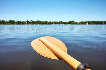 Wooden paddle over the water, selective focus.