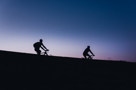 Beautiful Couple on bicycles silhouette sunset two bike ride