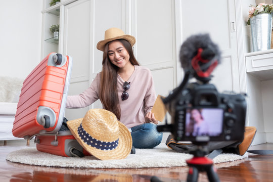 Asian young female blogger recording vlog video with vacation preparing to travel trip at home.online influcencer on social media concept.
