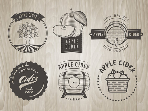 Vector cider labels and logos. Set of retro badges for apple cider drink. Vintage wooden background.