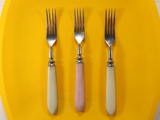 three forks on a yellow plate