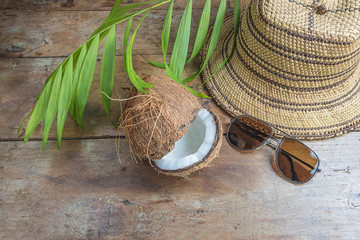 Travel destination concept: straw hat, sunglass,coconut and palm leaf on old wooden background...