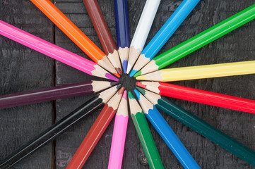Fototapeta premium Dusty multicolor pencils close up on wooden background