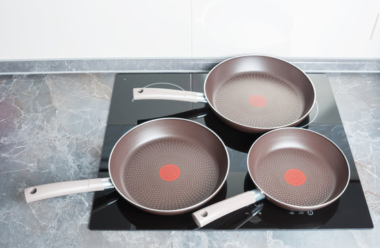 Three frying pans on electric stove