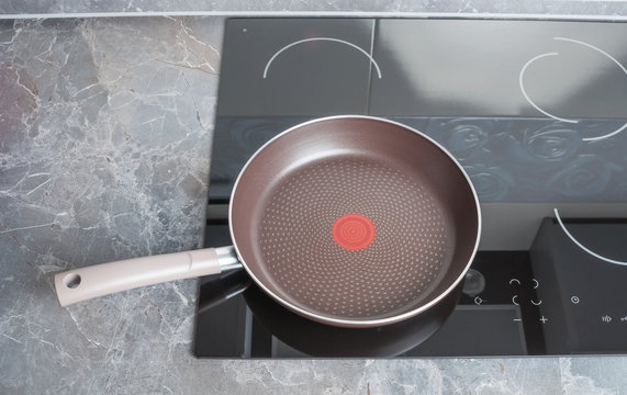 Modern electric stove with empty frying pan