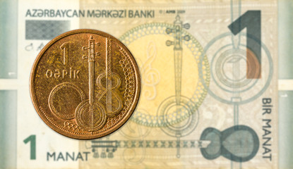 1 azerbaijani qepik coin against 1 azerbaijani manat bank note