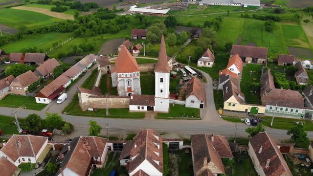 Aerial Drone 4K footage of Traditional village in Transylvania. Cloasterf Village. Medieval old church. in the village, Transylvania, Romania. Austro-Hungarian architecture. The church with a tower