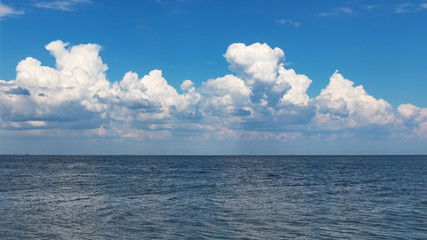 Naklejka na ściany i meble Blue sea under clouds sky 