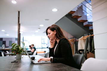 Young woman using laptop in open coworking office