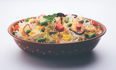 Indian Vegetable Pulav or Biryani made using Basmati Rice, served in a ceramic bowl. selective focus