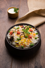 Indian Vegetable Pulav or Biryani made using Basmati Rice, served in a ceramic bowl. selective focus