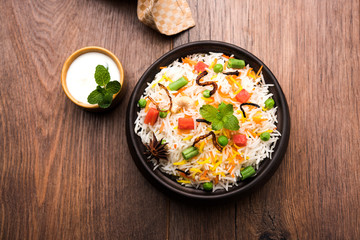 Indian Vegetable Pulav or Biryani made using Basmati Rice, served in a ceramic bowl. selective focus