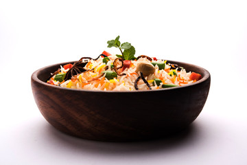 Indian Vegetable Pulav or Biryani made using Basmati Rice, served in a ceramic bowl. selective focus