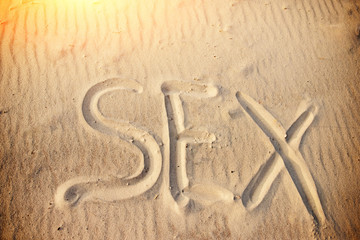 sex handwritten in sand on a beach