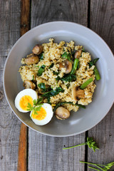 Warm bulgur salad with fried mushrooms, asparagus and spinach