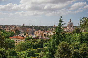 Fototapeta na wymiar Overview of trees, cathedrals domes, monuments and roofs on a cloudy day at Rome, the incredible city of the Ancient Era, known as 