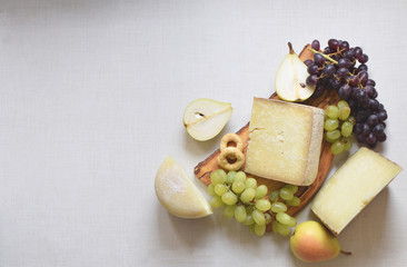 Italian cheese appetizer with grape and pears, copy space, top view