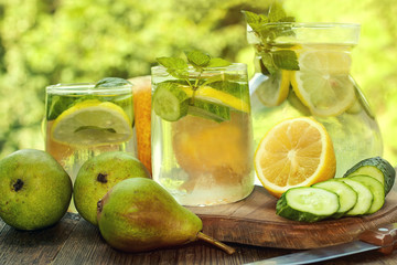 Detox water in a pitcher and glasses with cucumbers, lemon and mint leaves. close-up.