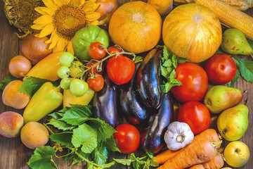 A lot of vegetables and fruits on a wooden surface. Big harvest.