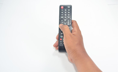 Hand is holding the TV remote to control.