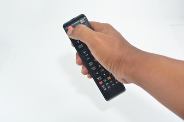 Hand is holding the TV remote to control.