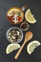 Glass Cup of Herbal Tea with Acacia Flowers and honey on Black Background, top view, Copy space. Health Drink Coldness