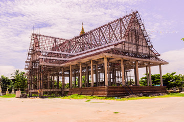 Thai Buddhist church in local of Thailand under construction against the blue sky background