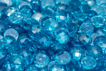 Closeup of many small blue zircon gemstones. Bright luxury background.