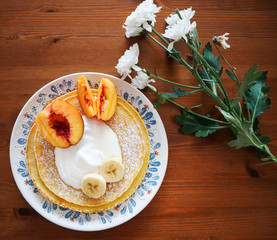 Pancakes with a little bit of cream, banana and peach