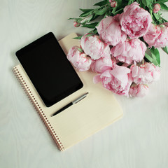 flat lay concept with tablet, writing pad, pen and beautiful peonies, can be used as background