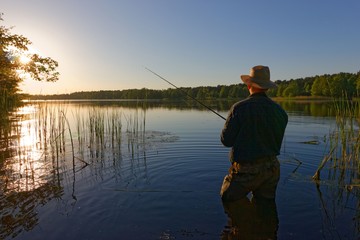 fisherman in the rays of the setting sun