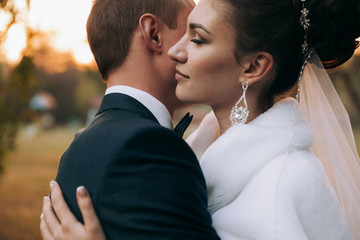 Couple in love. Newlyweds looking at each other  Young couple at sunset  Wedding dress and bouquet The bride and groom Portrait bride Close-up of bride and bridegroom looking at each other