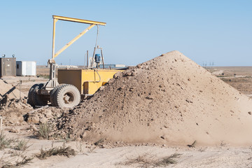 The mountain of clay near the drilling rig.