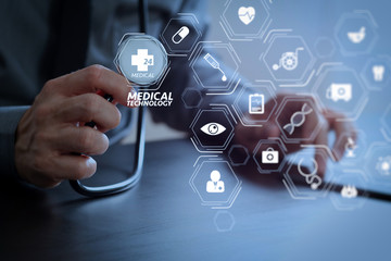 close up of smart medical doctor working with stethoscope and mobile phone on dark wooden desk in modern hospital