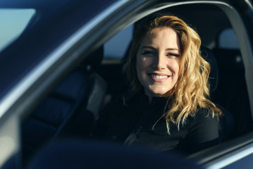 Fototapeta na wymiar Smiling woman in the car on a summer day.