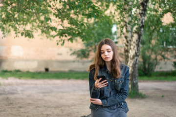 Fototapeta premium Young female girl with smartphone