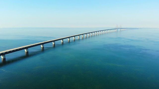 Aerial view of modern Oresund Bridge between Denmark and Sweden (Copenhagen and Malmo), clear blue sky, seascape of Baltic Sea with diagonal composition of very long sea bridge disappearing on horizon